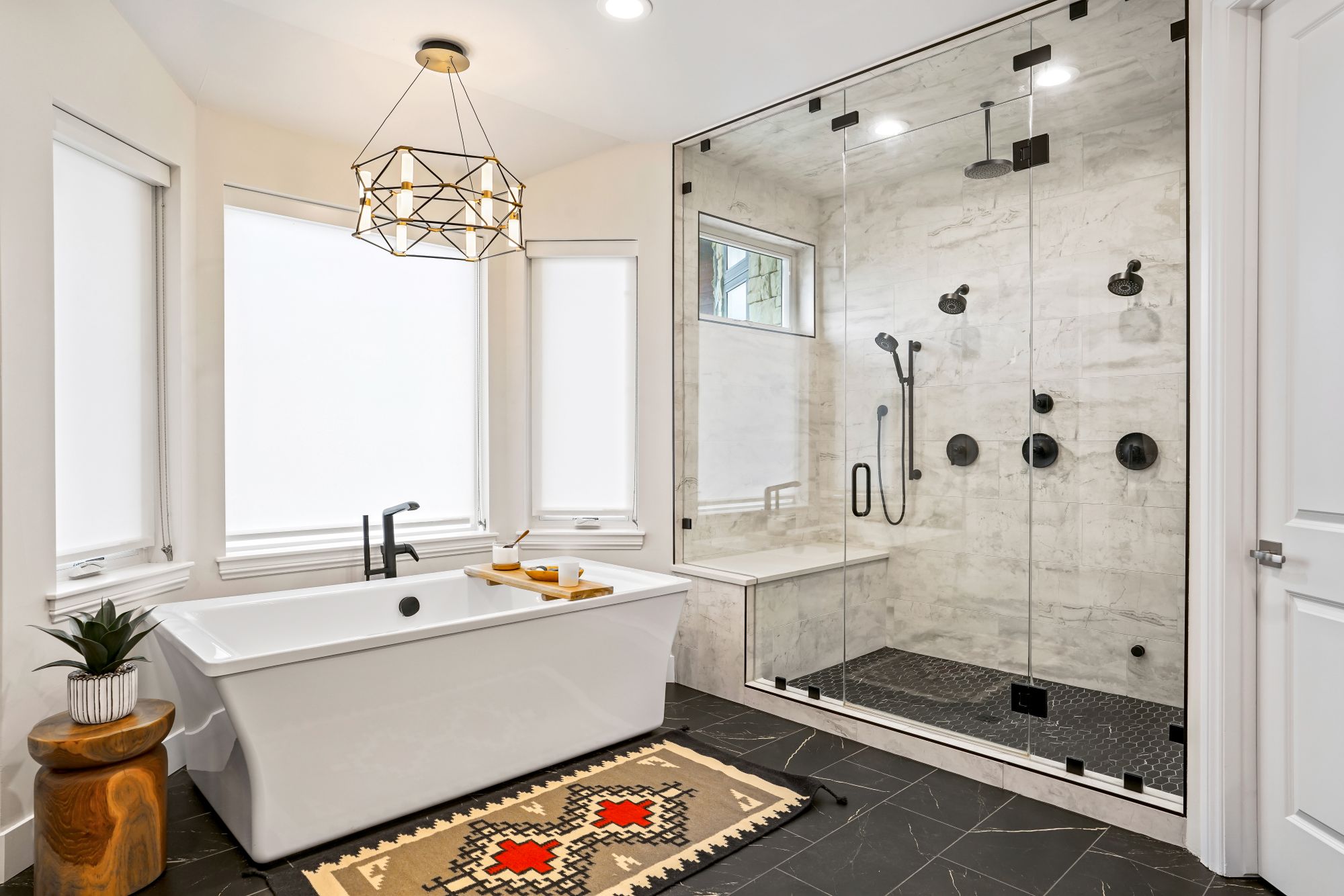 Completed bathroom remodel by Next Step Innovations with new glass shower doors and stand alone bathtub